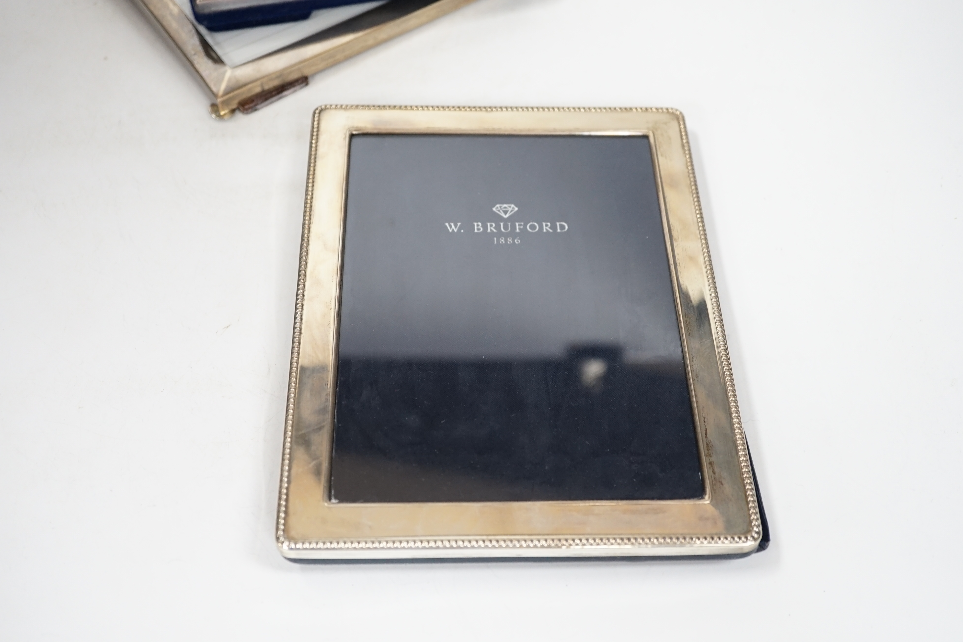 Two modern sterling silver mounted photograph frames, 21cm and a larger unmarked frame, 25cm